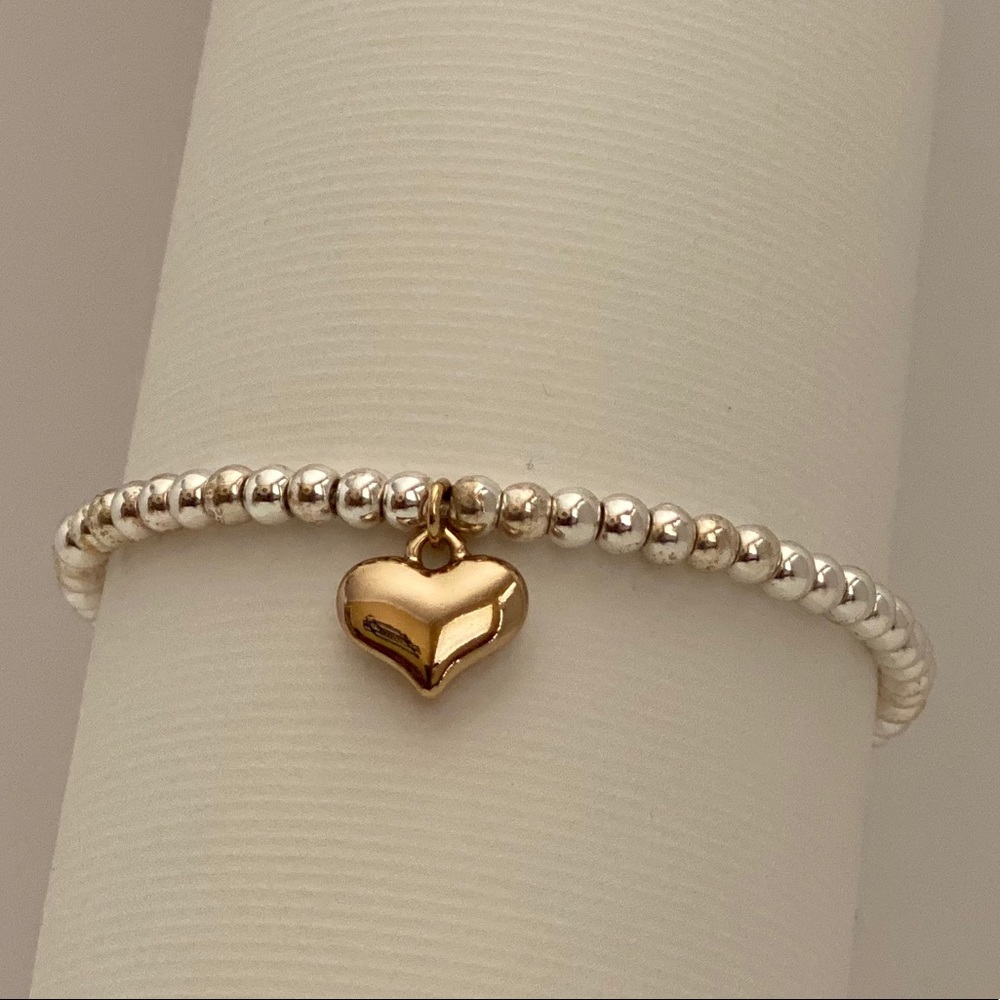 Silver love bracelet with gold heart.